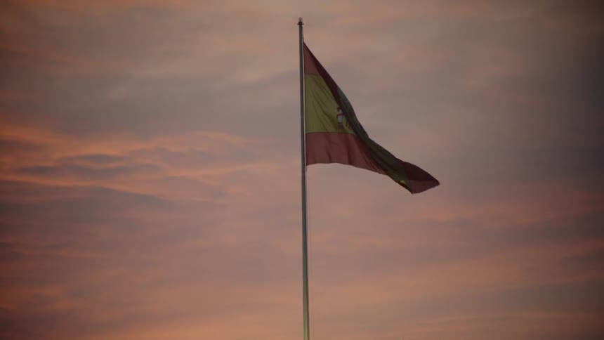 Flag waves in the wind at sunset