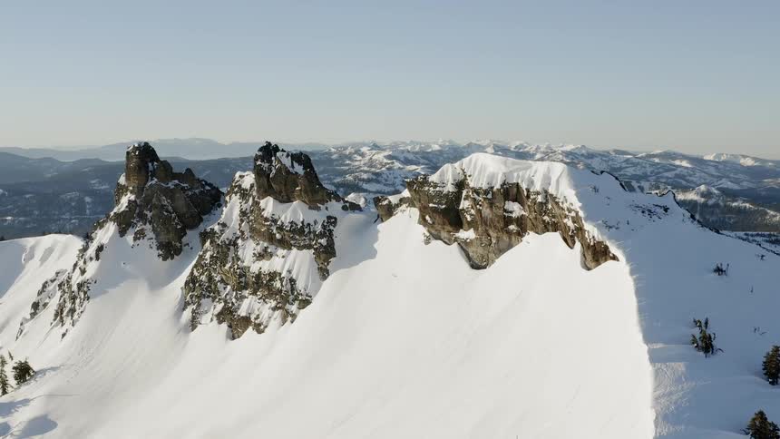 Snow covers mountain peaks at sunset