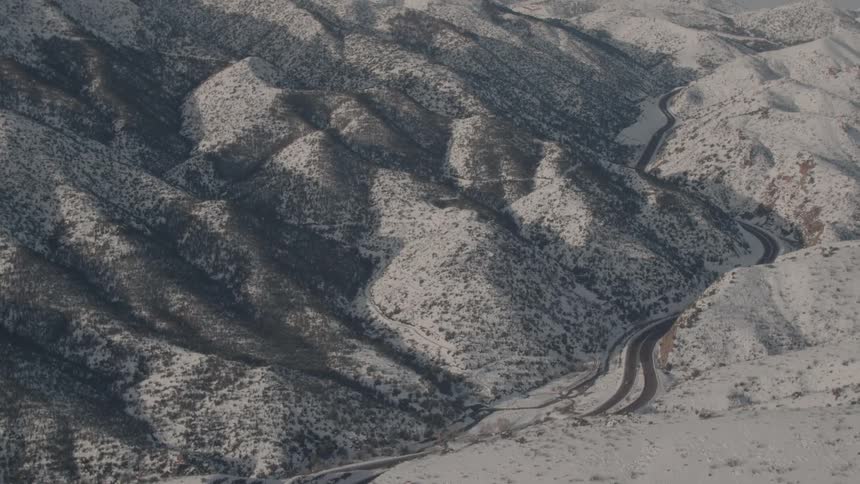 A vehicle travels in snowy mountains