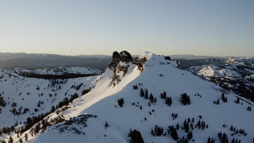 The sun sets over snowy mountains
