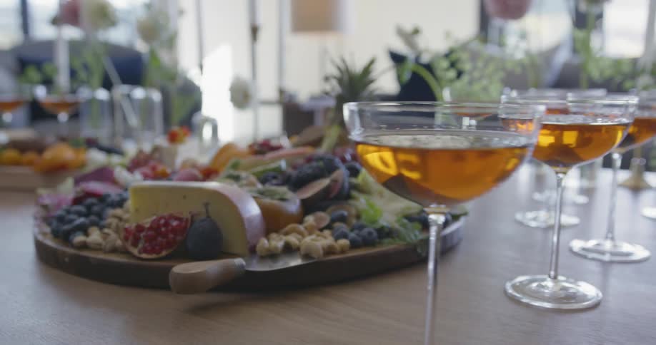 Cocktails and food are sitting ready on a table inside a home in daylight