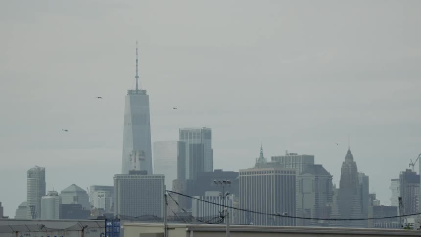 Objects fly around a tall building in a city