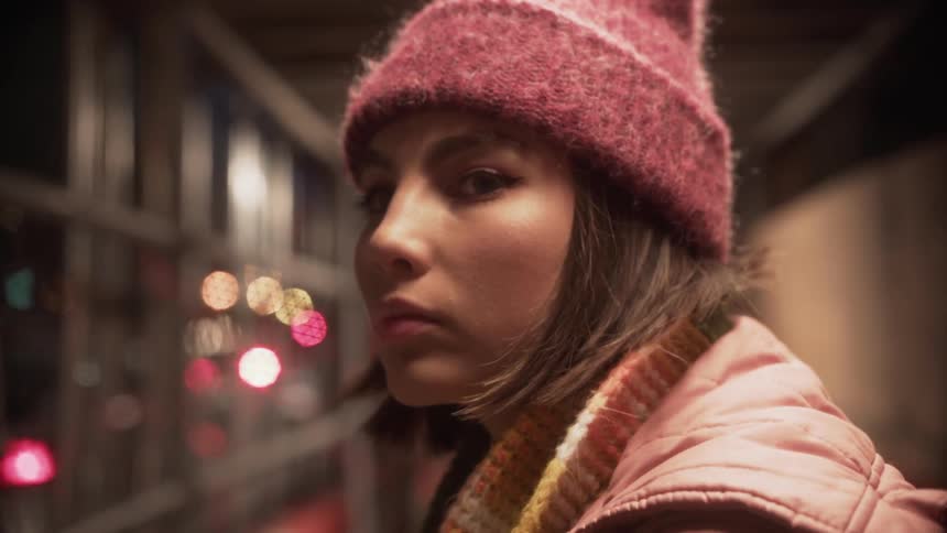 Woman wearing a toque lowers her head as she blinks her eyes