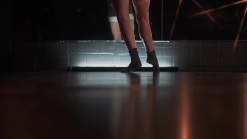A woman is dancing in front of a mirror