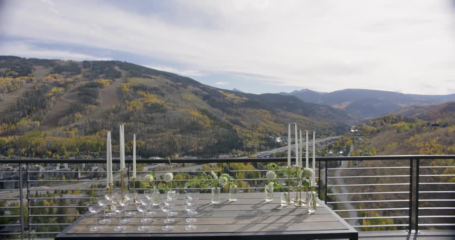 Glasses and candles sit on a balcony table