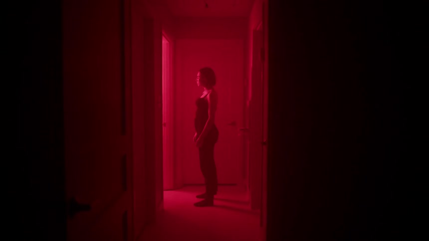 Woman stands in a hallway with flashing red lights