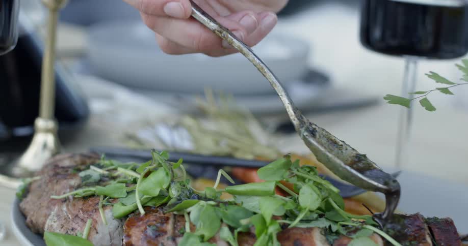 A sauce is poured onto a meat plate