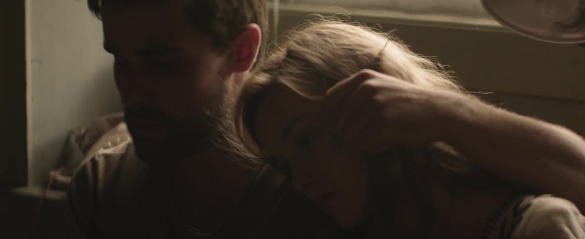 Man holding a woman by a window