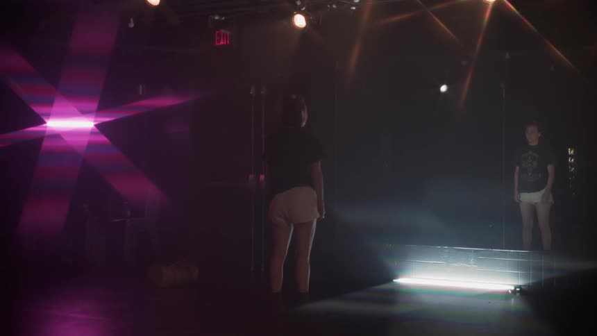 Woman stares at a mirror in a dance studio