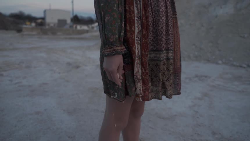 A woman stands on the field at sunset