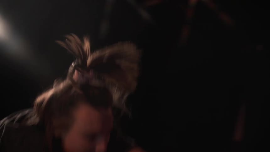 A woman is moving around dancing in the dark