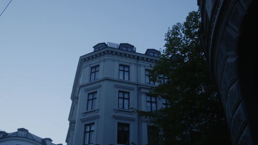 Trees sit between the buildings under a blue sky