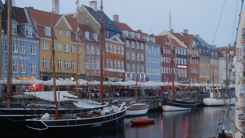 The boats are docked in the water near the buildings