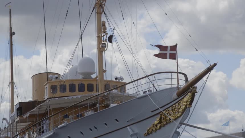 A boat is docked in the water with a flag on top