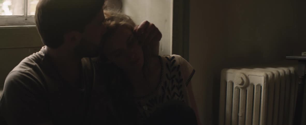 A man puts his arm around a woman