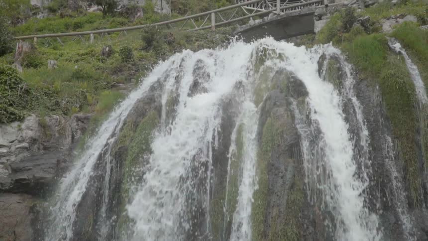 A waterfall flows over a cliff