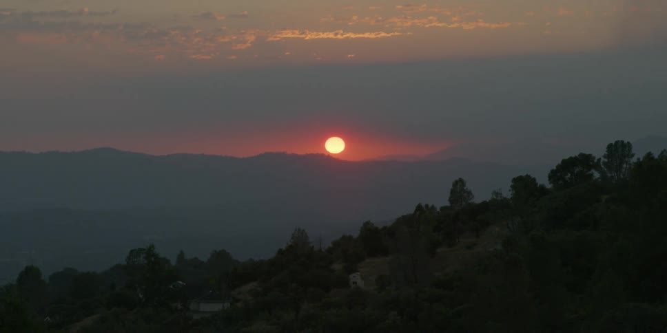 The sun sets over mountains