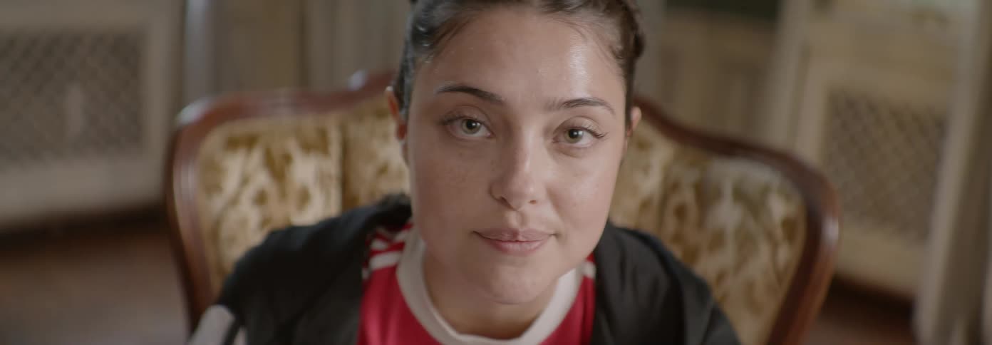 A woman is sitting down talking to someone