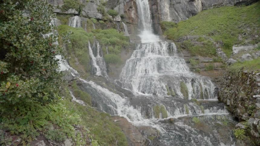 The waterfall is pouring down into the stream