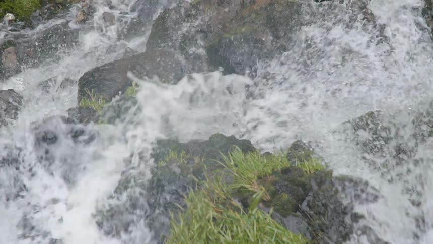 Water splashes over large rocks and down a river