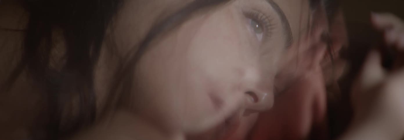 A woman is laying down with her eyes open