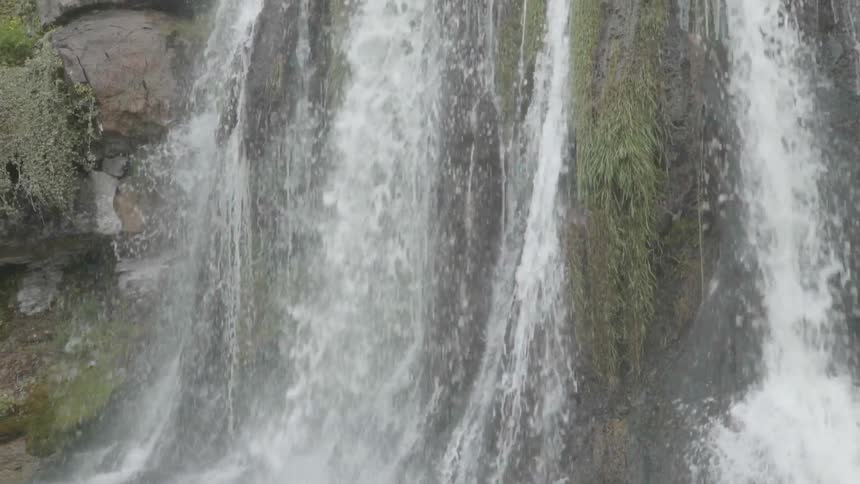 A waterfall flows over a cliff