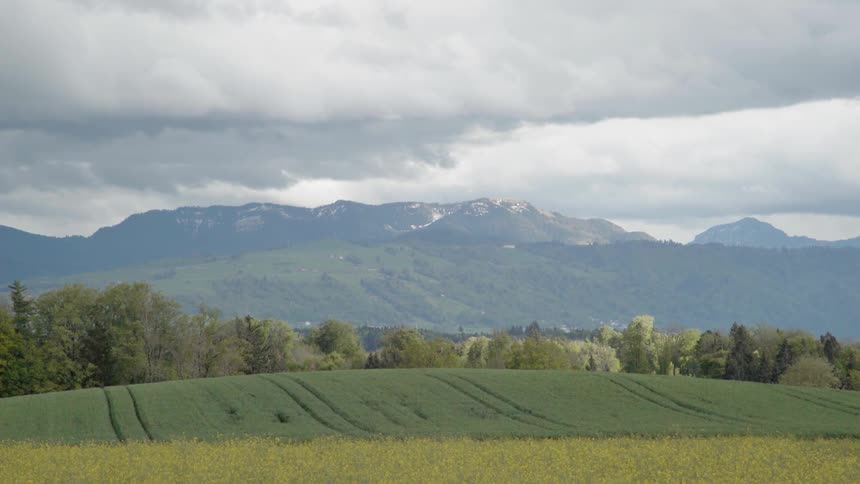 Clouds move over hills and farmland