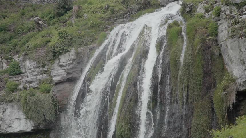 A waterfall flows over a cliff