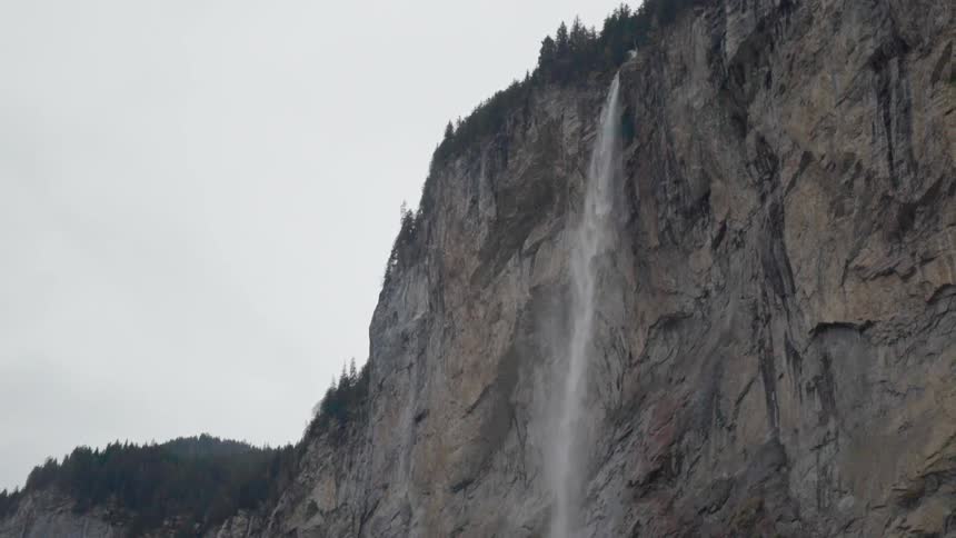 Waterfall splashes down off a large cliff
