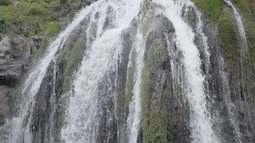 Water splashes down rock formations into a stream below
