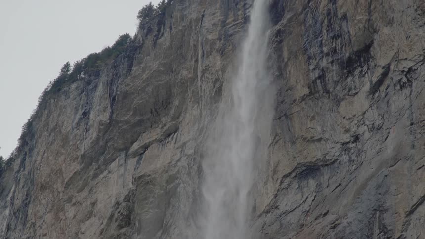 A waterfall flows over a tall cliff