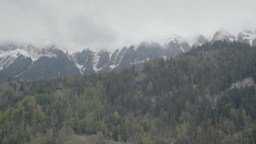 Clouds float above snowy mountains