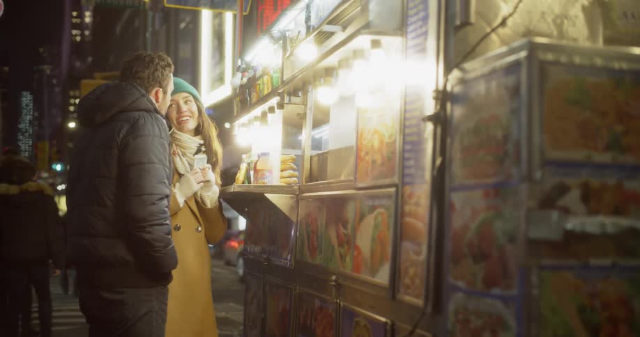 Man and woman order food at a food cart