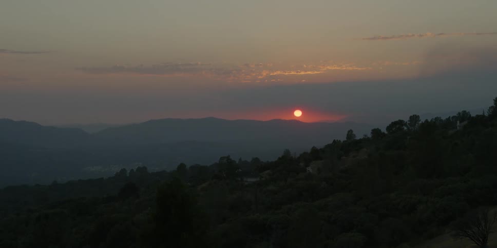 The sun sets over mountains