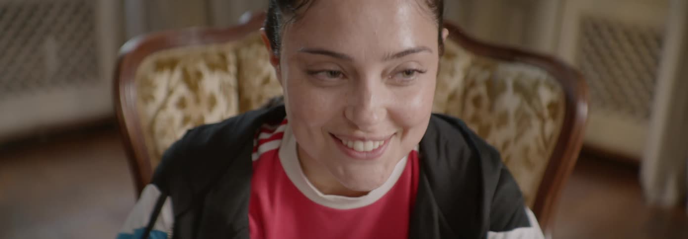 A woman smiles and talks while seated