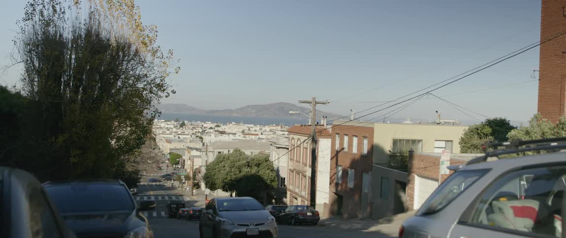 Cars travel up a sloped city street