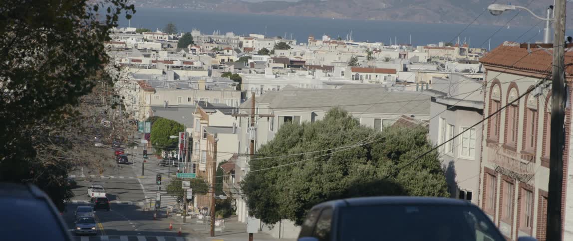 Cars travel uphill on the street in town