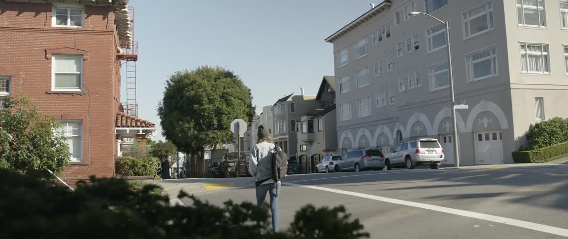 A pedestrian walks on a city sidewalk