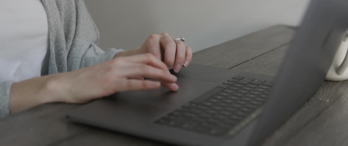 A woman uses the trackpad on her laptop