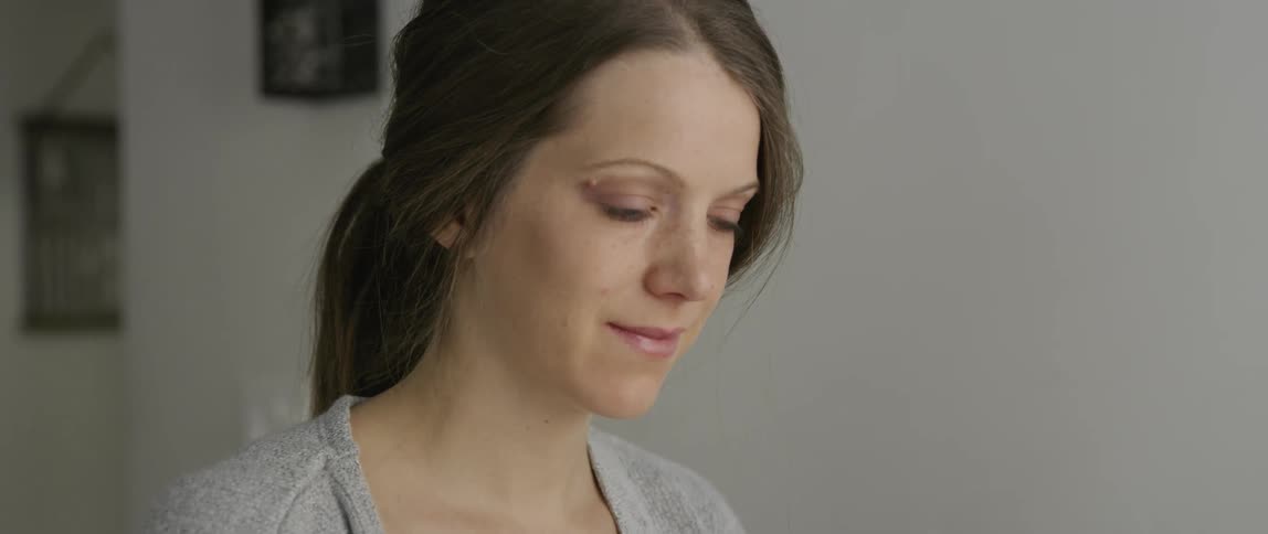 A woman sits down smiling