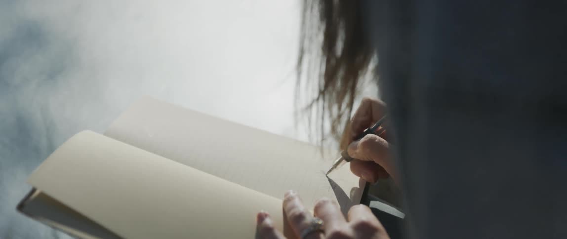 A woman writes in a notebook