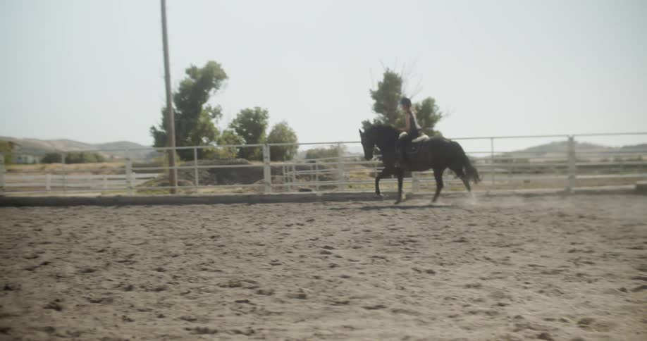 Woman rides a horse on a ranch