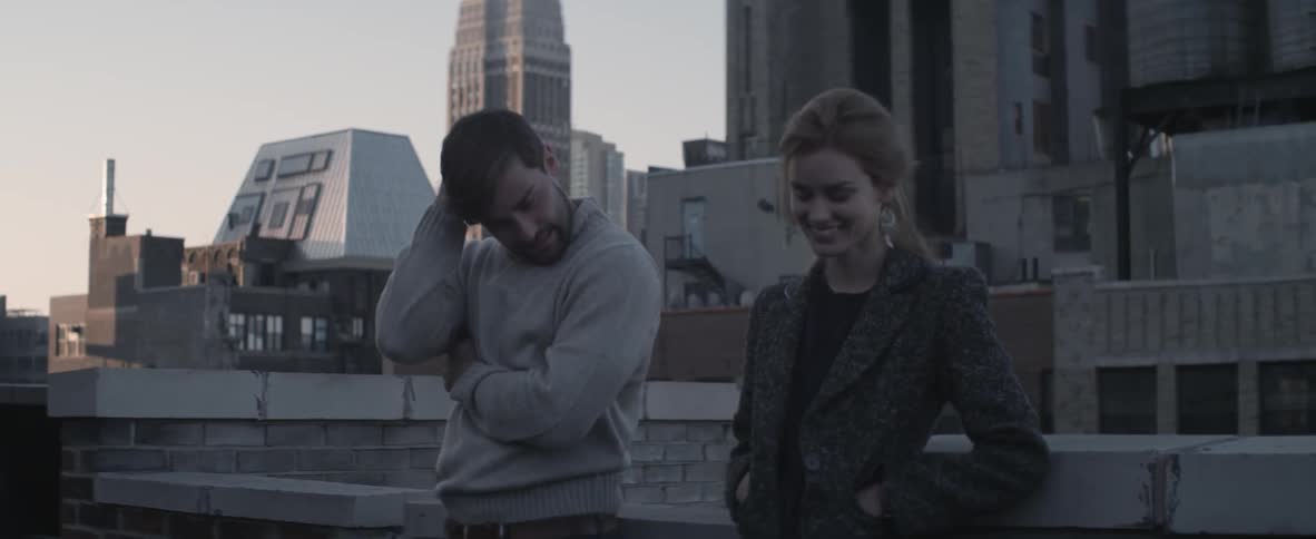 A man and woman on a rooftop in the city