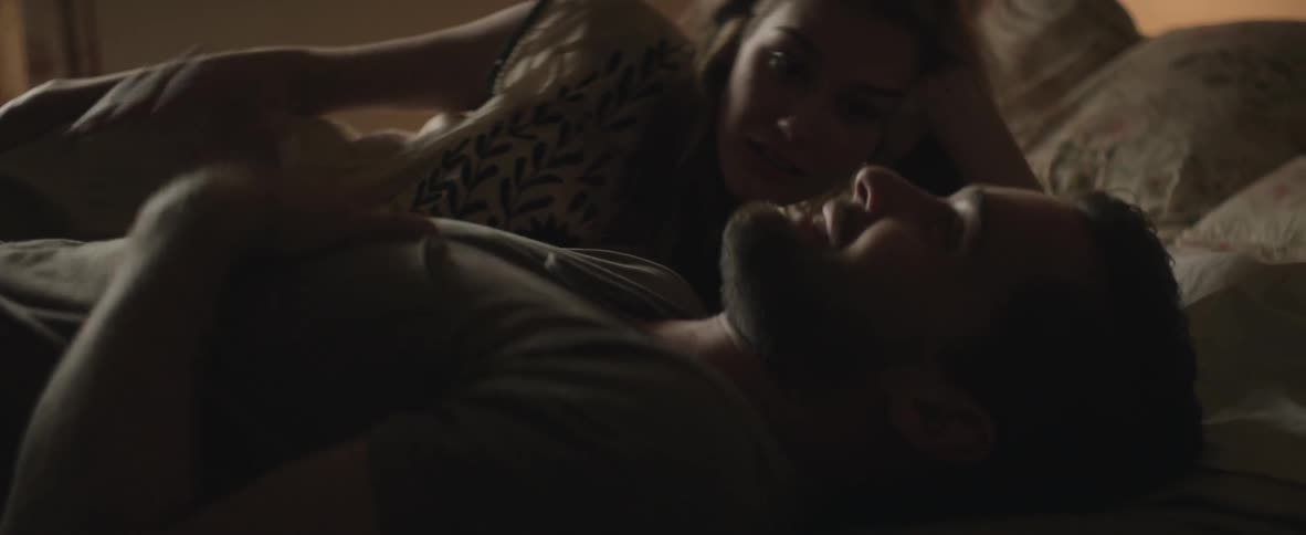 A couple in bed talking to one another