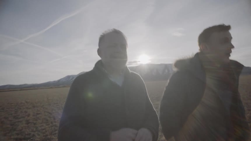 Two men walking through field during winter