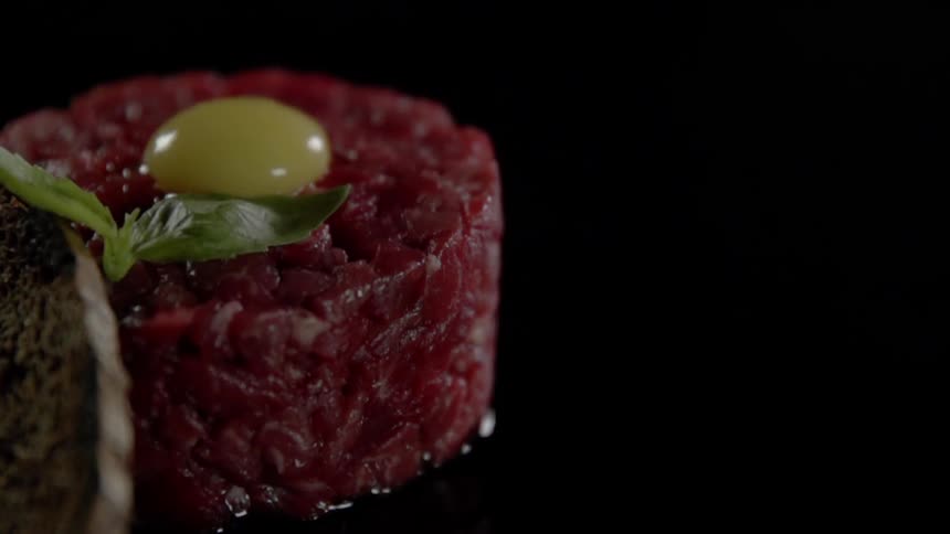 Leaf falls on a tartar with an egg yolk on top