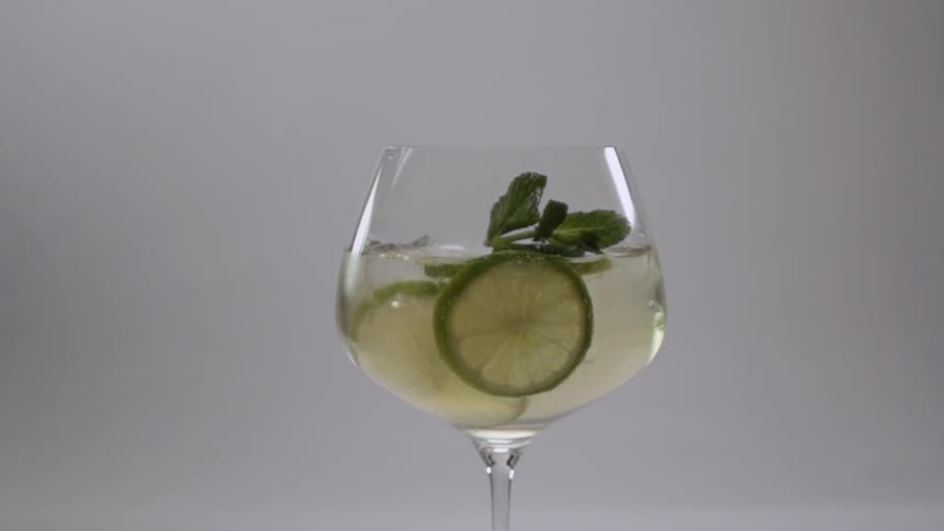 Mint leaves are dropped into a glass