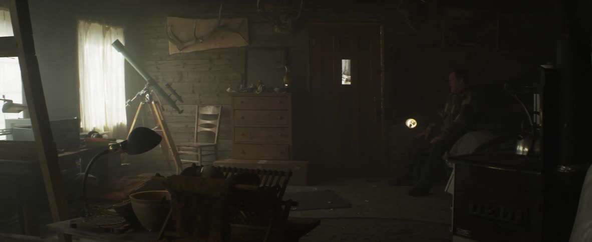 A man in distress aims a gun in his living room, before cowering in a corner