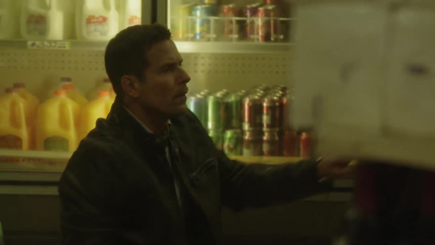The man crouches down checking items on the shelves