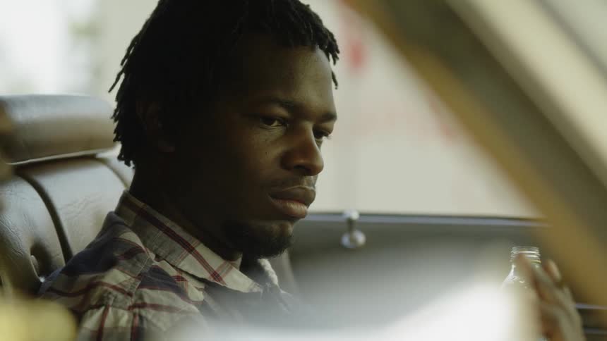 A man sits in the car smoking